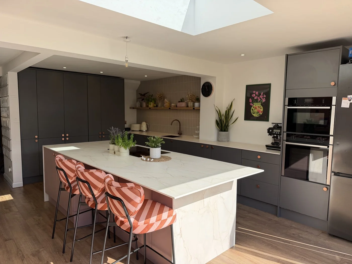 Panda Projects kitchen extension with a pink island, dark cabinetry and rooflight